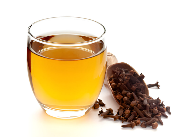 A glass of clove water on a bedside table, perfect for drinking clove water before bed.