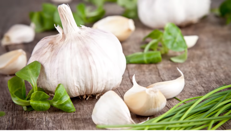 Eat garlic every day – A basket of fresh garlic cloves, highlighting the health benefits of daily garlic consumption for heart health, immunity, and detox.